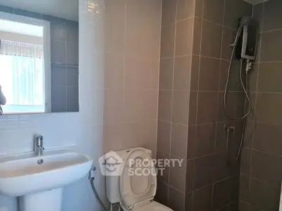 Modern bathroom with sleek gray tiles and a wall-mounted shower heater.