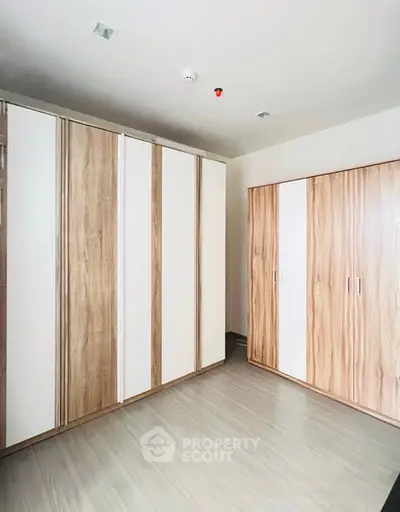 Spacious bedroom with modern wooden wardrobes and sleek flooring