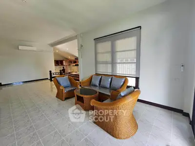 Spacious living room with elegant wicker furniture and open kitchen layout