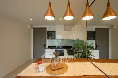 Modern kitchen with sleek design, featuring pendant lights and a stylish dining setup.