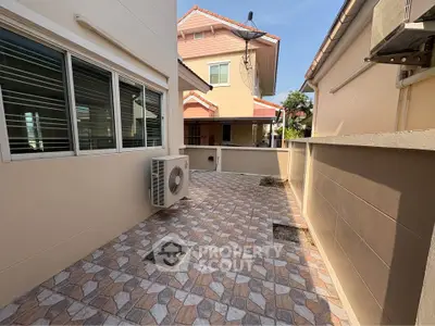 Spacious outdoor patio area with tiled flooring and air conditioning unit, perfect for relaxation.