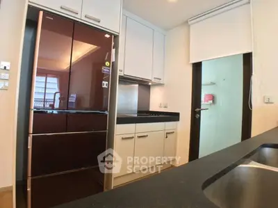 Modern kitchen with sleek appliances and ample storage in a stylish apartment.