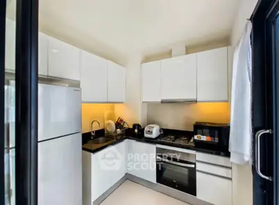 Modern kitchen with sleek white cabinets and built-in appliances.