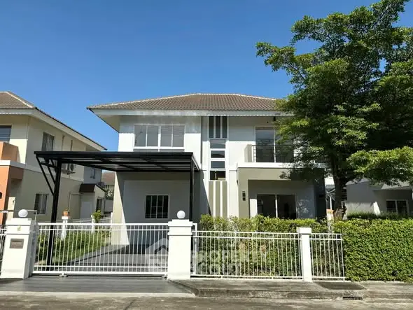 Charming two-story house with modern design and lush greenery in a serene neighborhood.