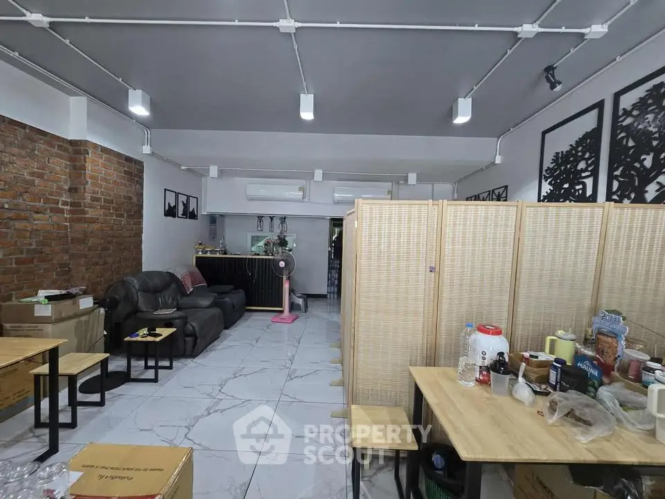 Spacious living room with modern decor and exposed brick wall