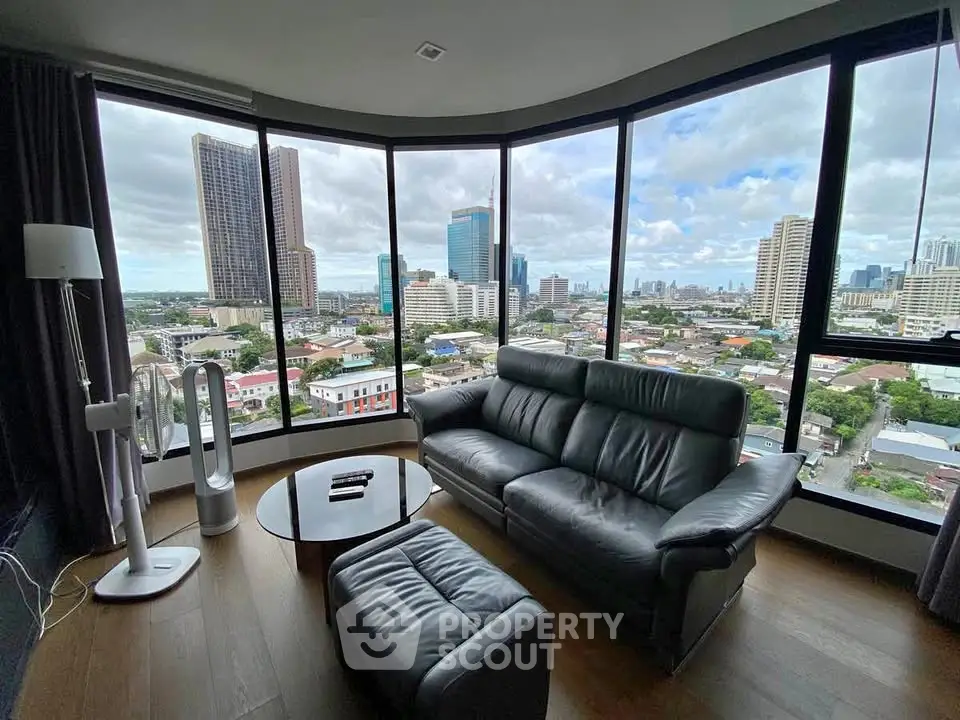 Spacious living room with panoramic city view and modern furnishings.