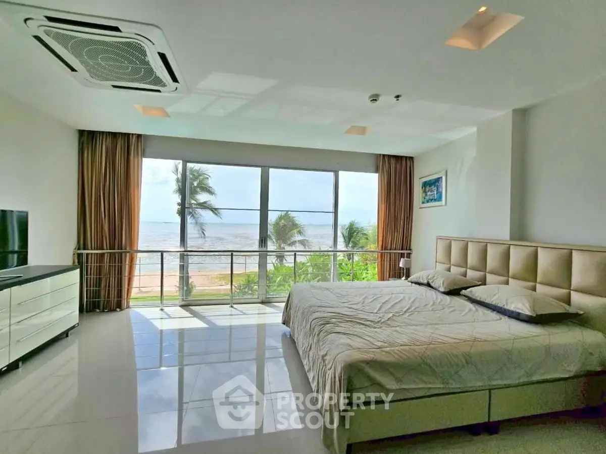 Luxurious beachfront bedroom with stunning ocean view and modern decor.
