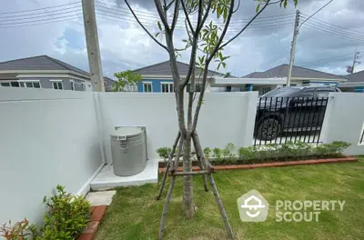 Charming garden view with modern fence and lush greenery in suburban neighborhood.