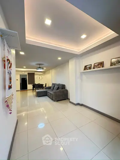Spacious modern living room with elegant ceiling lights and cozy gray sofa, perfect for family gatherings.
