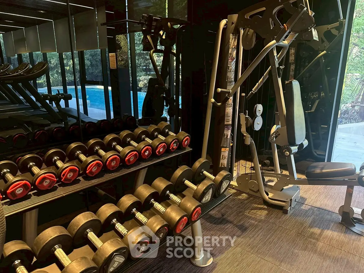 Modern gym with weights and exercise equipment in luxury real estate setting.