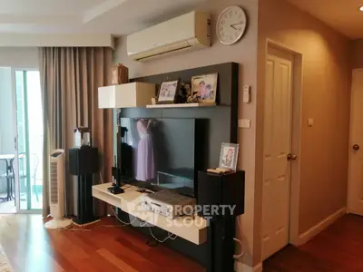 Stylish living room with modern entertainment center and balcony access.
