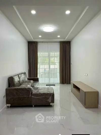 Modern living room with sleek furniture and large window for natural light.