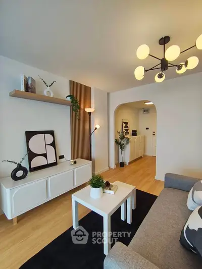 Modern living room with stylish decor, wooden flooring, and contemporary lighting.