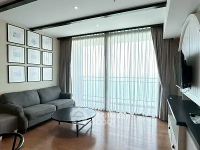 Spacious living room with modern decor and large windows offering abundant natural light.