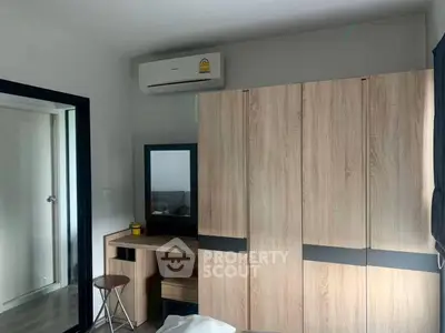 Modern bedroom with sleek wooden wardrobe and air conditioning unit