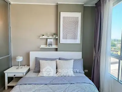 Modern bedroom with stylish decor and large window offering natural light and scenic view.