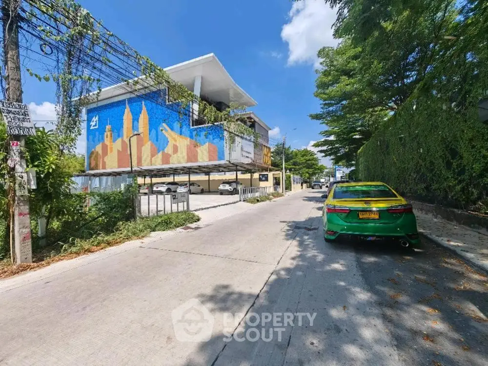 Modern building exterior with vibrant mural and street view, showcasing urban living.