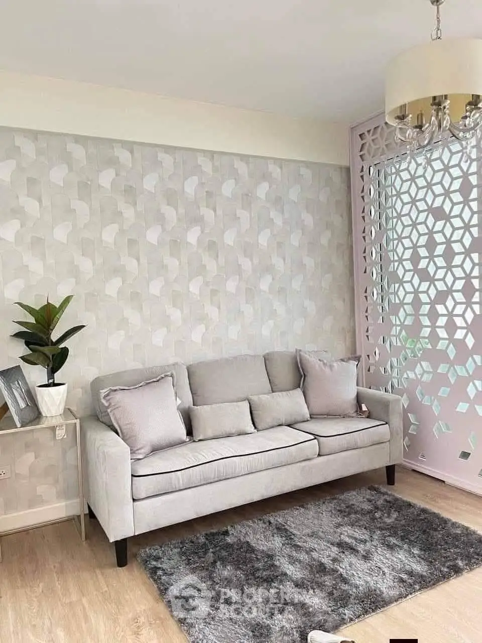 Elegant living room with modern decor, featuring a stylish sofa, chic wallpaper, and a plush rug.