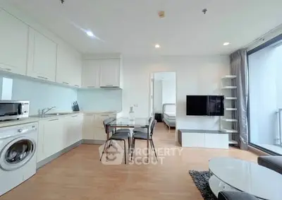 Modern open-plan kitchen and living area with sleek appliances and stylish decor.