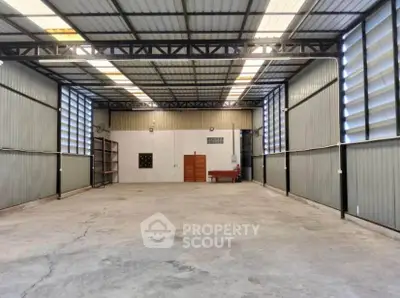 Spacious industrial warehouse with high ceilings and ample natural light.