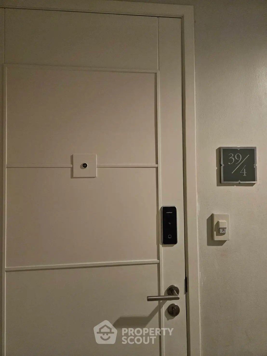 Modern apartment entrance with digital lock and room number 39/4, showcasing secure living.