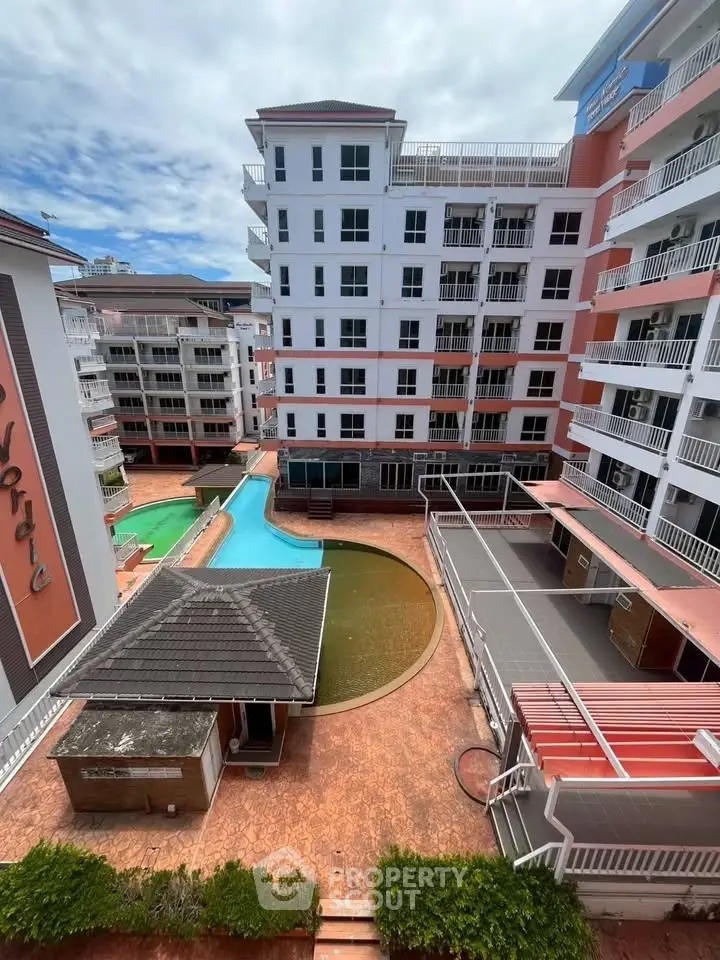 Stunning view of modern apartment complex with pool and spacious balconies.