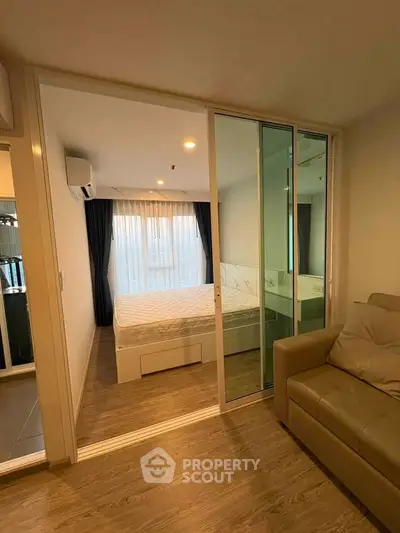 Modern apartment with sliding glass doors leading to a cozy bedroom featuring a large window and stylish decor.