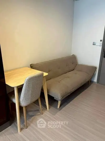Cozy living room with modern sofa and wooden table, perfect for compact urban living.
