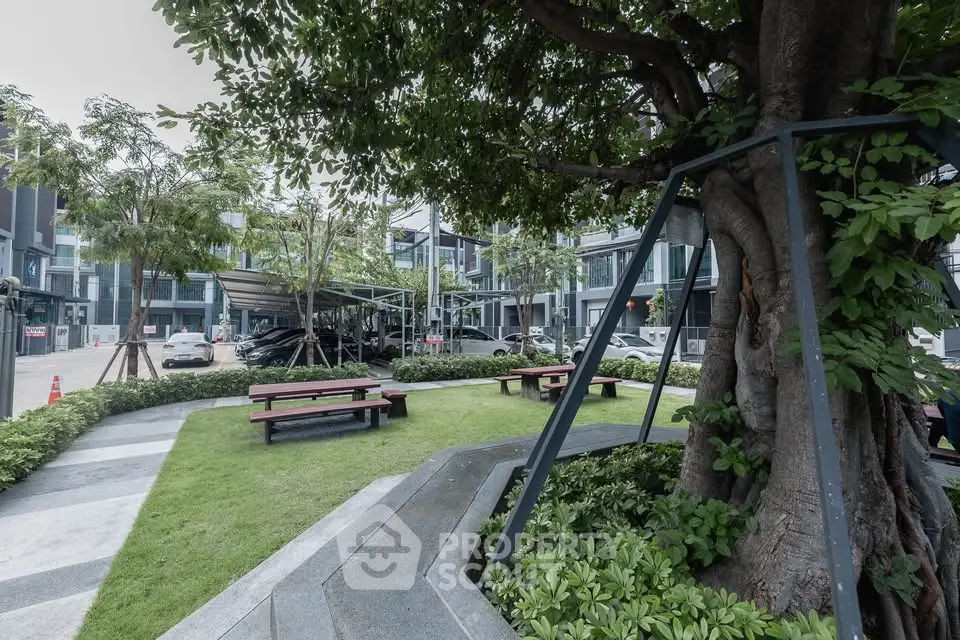 Modern residential complex with lush garden and parking area