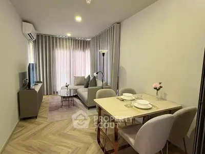 Modern living room with dining area, featuring elegant decor and natural light.