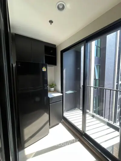 Modern kitchen with sleek black appliances and balcony view