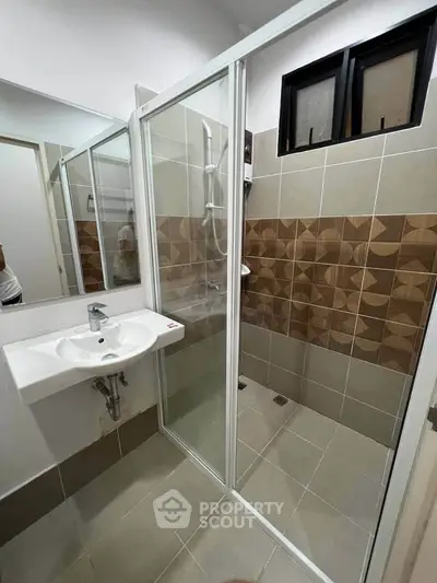 Modern bathroom with glass shower enclosure and stylish tile design