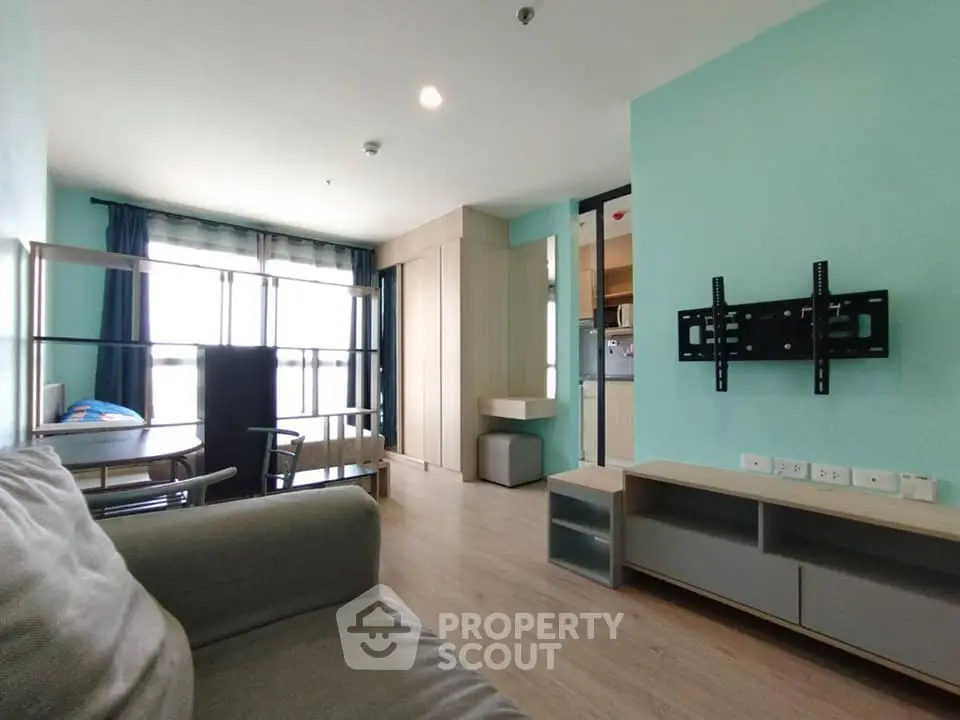 Modern living room with natural light and open kitchen layout in stylish apartment.