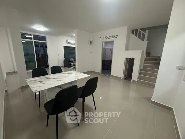 Spacious modern dining area with sleek marble table and elegant black chairs
