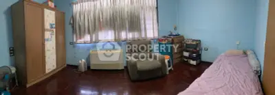 Cozy bedroom with wooden flooring, comfortable armchair, and ample storage space.