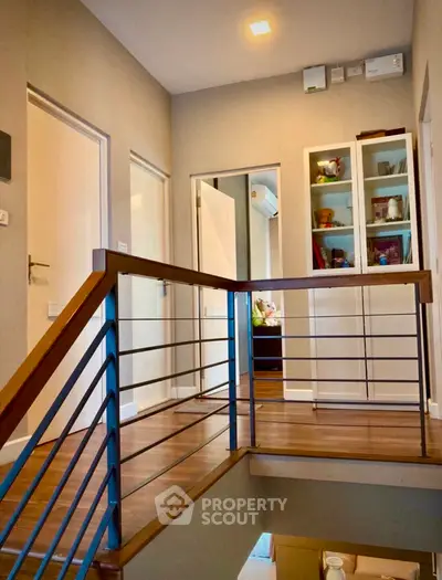 Modern hallway with wooden flooring and sleek railing design