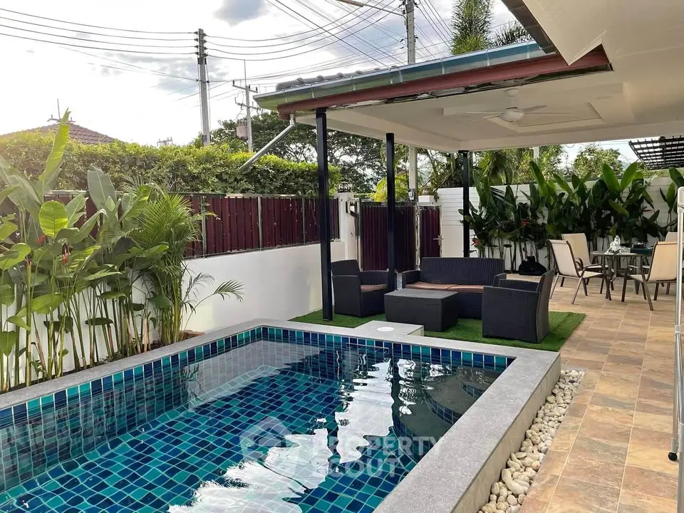 Charming outdoor pool area with modern seating and lush greenery, perfect for relaxation and entertaining.