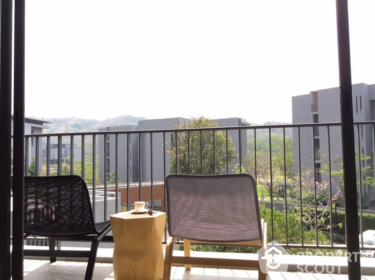 Spacious balcony with a serene view, perfect for relaxation, featuring modern outdoor furniture and a tranquil natural backdrop.