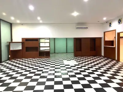Spacious room with checkered flooring and built-in wooden shelves, ideal for versatile use.