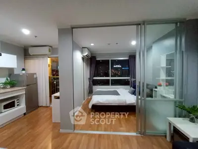 Modern studio apartment with open layout and city view, featuring sleek kitchen and cozy bedroom.