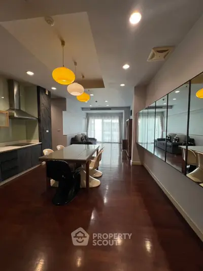 Spacious modern dining area with stylish lighting and large mirrors, perfect for entertaining.