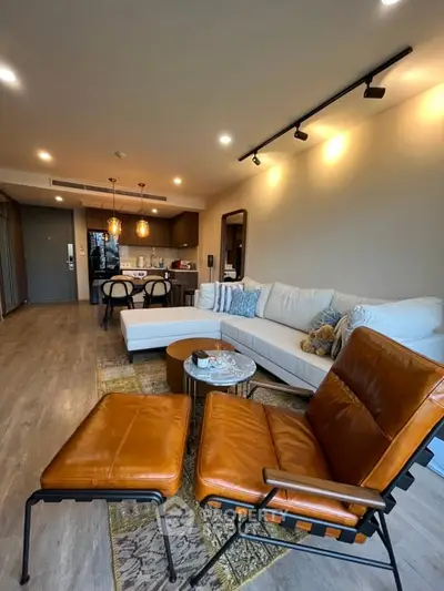 Modern living room with stylish leather chairs and cozy sectional sofa in open layout apartment.
