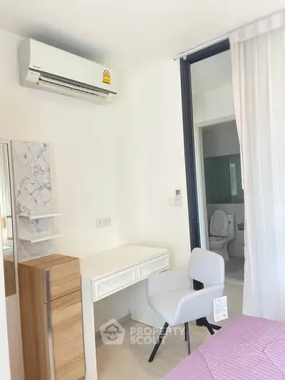 Modern bedroom with air conditioning and ensuite bathroom in a stylish apartment.