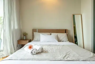 Cozy bedroom with natural light and modern decor, featuring a comfortable bed and elegant furnishings.