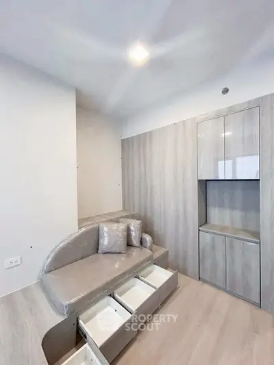 Modern minimalist living room with built-in storage and sleek furniture design.