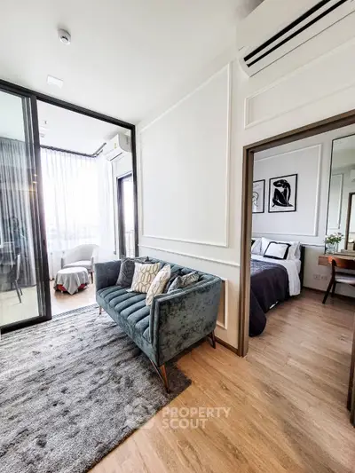 Modern living room with elegant decor and cozy bedroom view, featuring stylish furniture and natural light.