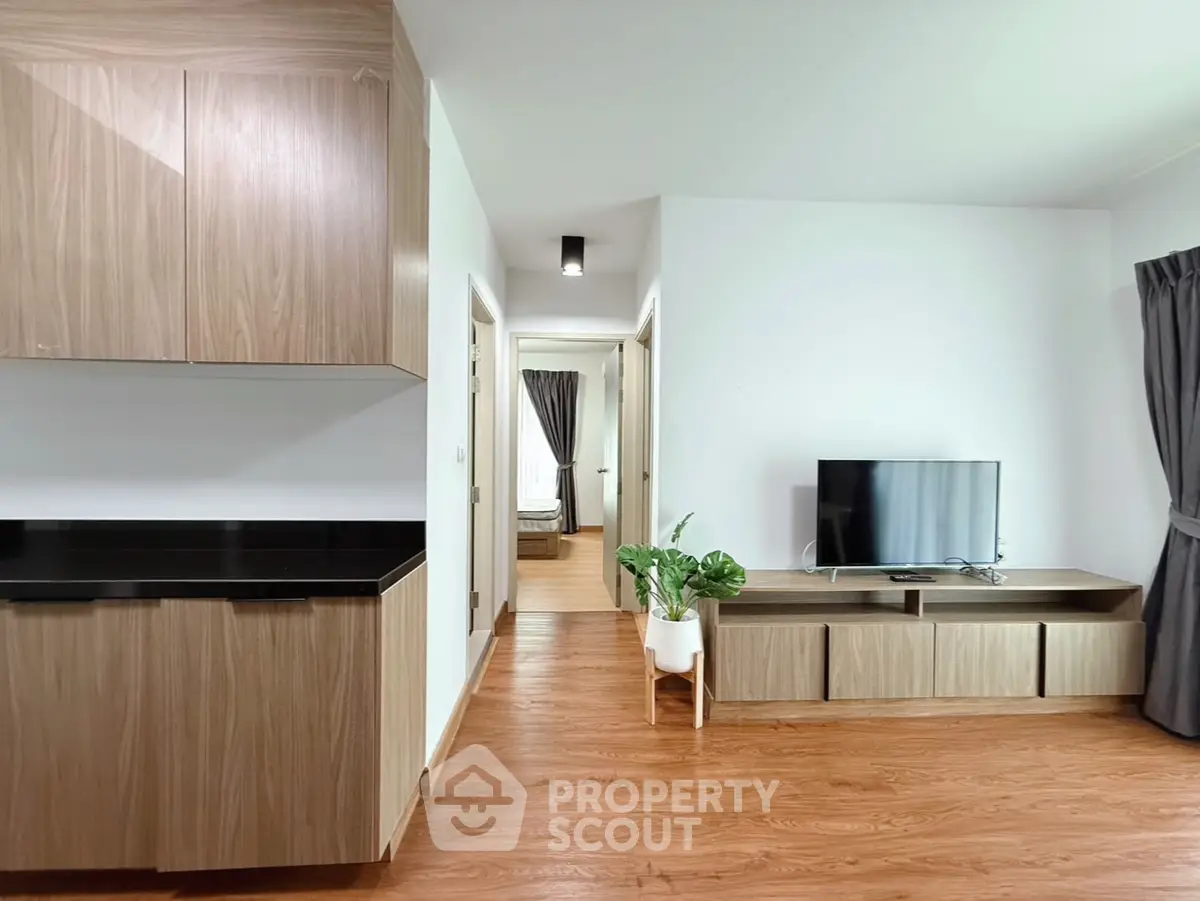 Modern living room with wooden flooring and sleek cabinetry