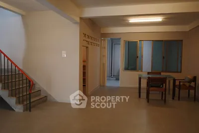 Spacious open-plan living area with modern staircase and natural light