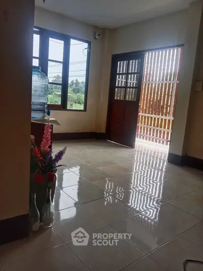 Bright entrance area with tiled flooring and large windows for natural light.