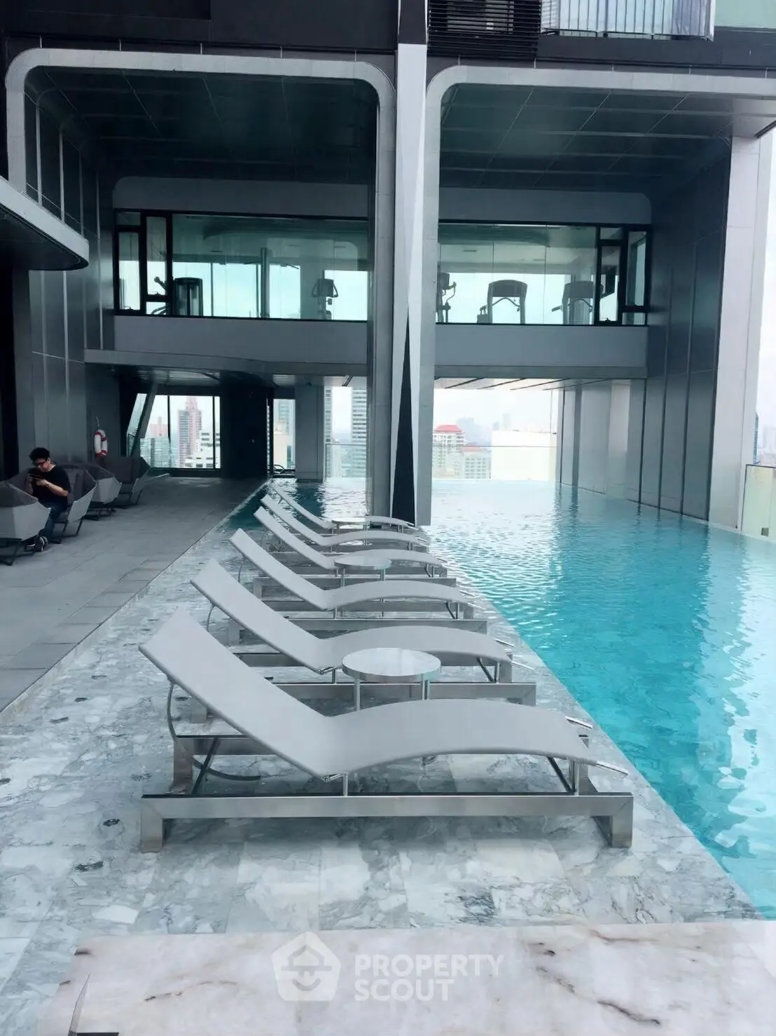Luxurious rooftop pool with modern lounge chairs and city view
